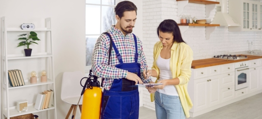 An exterminator showing something to the owner