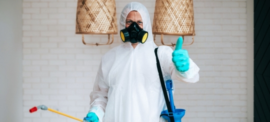 A selfie of an exterminator with his thumbs up